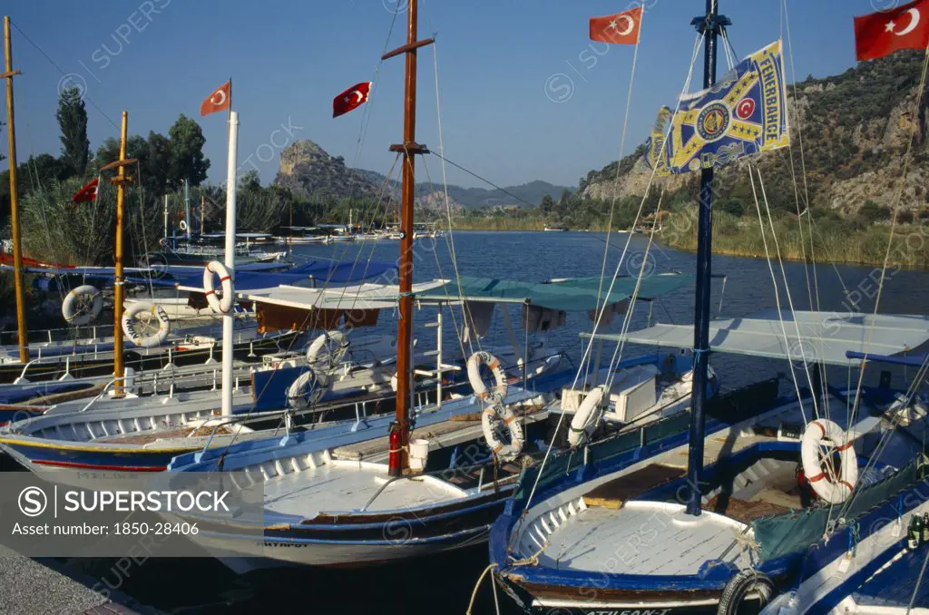 Turkey, Mugla, Dalyan, Harbour With Moored Boats Displaying Turkish Flags
