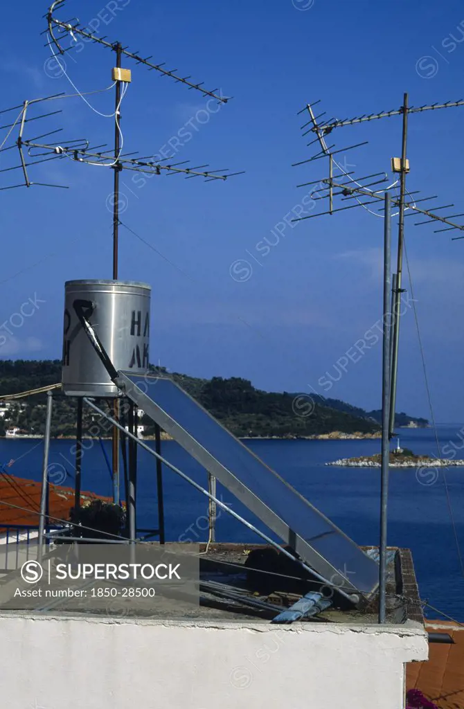 Environment, Energy, Solar Power, Solar Power Panel Amongst Aerials On The Roof Of A House In Greece
