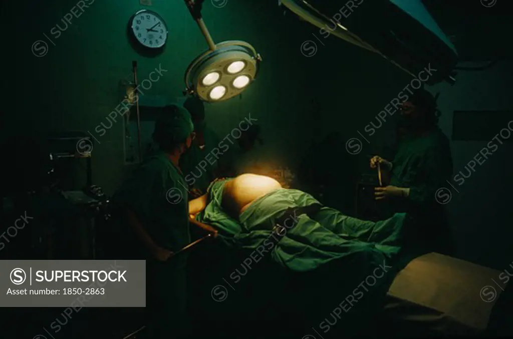 Cuba, Havana, Woman In Labour Lying On An Operating Table At The Maternity Hospital With Lamps Above Her Belly