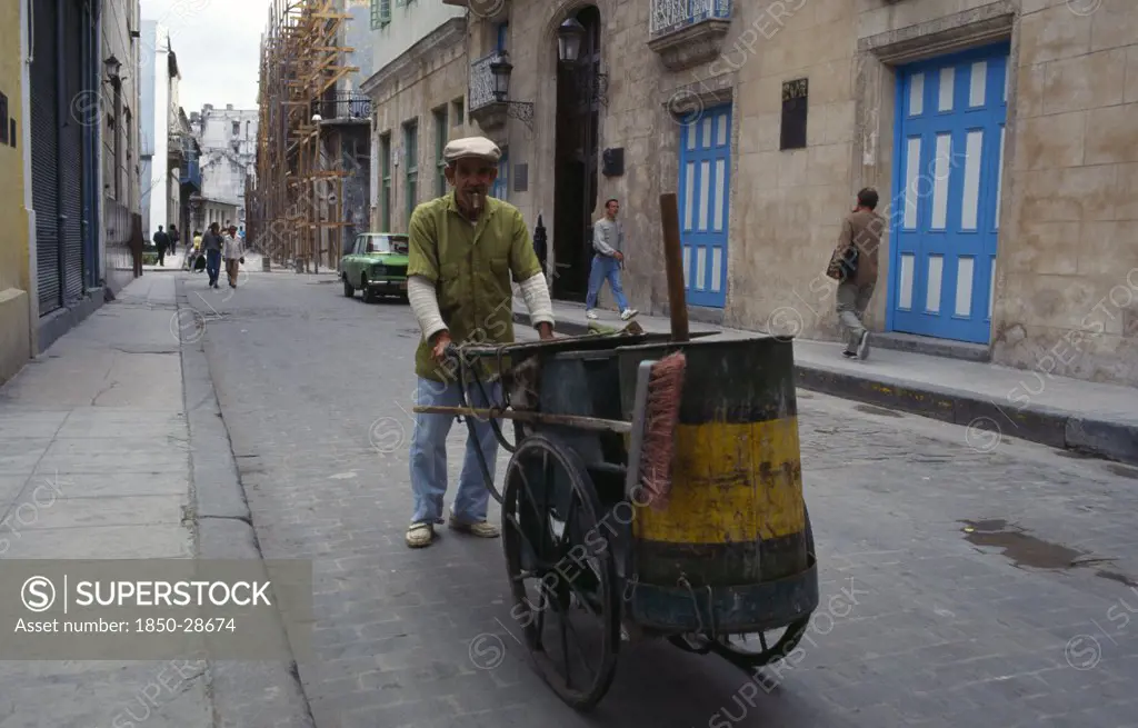 Cuba, Havana , Street Cleaner Pushing Hand Cart And Smoking Cigar.