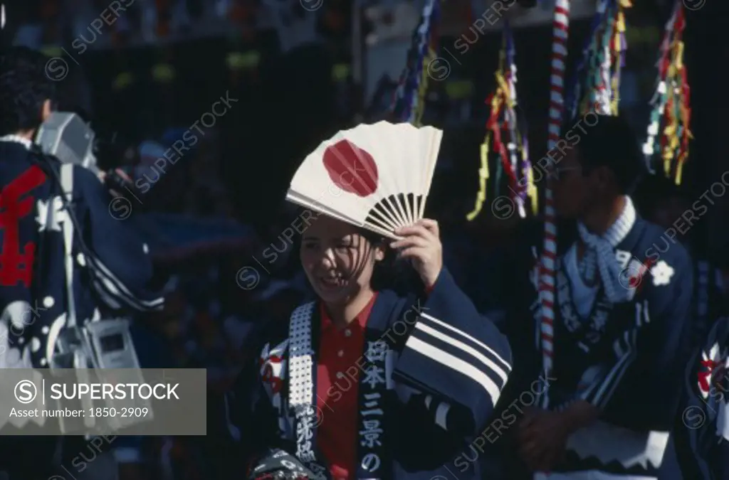 Japan, Honshu, Miyajima, Woman At The Autumn Sake Festival Holding A Fan With The Design Of The Japanese Flag On It