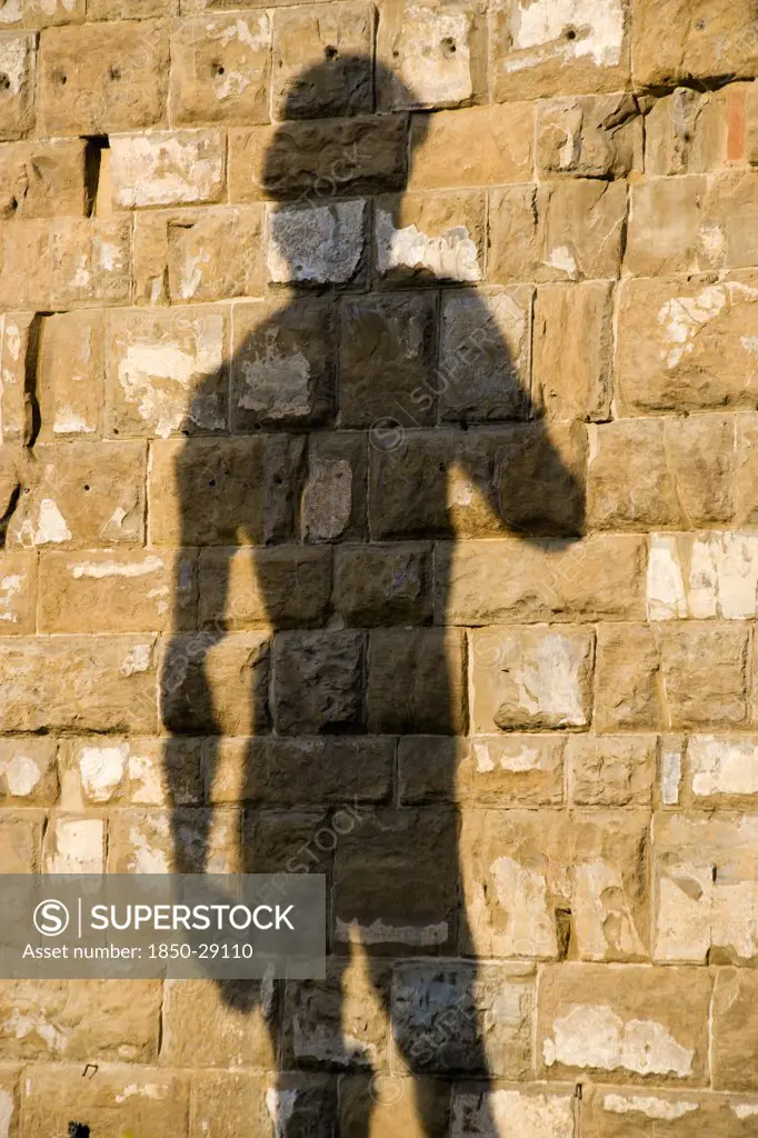 Italy, Tuscany, Florence, Shadow Of The Replica Renaissance Statue Of David By Michelangelo On The Wall Of The Palazzo Vecchio In The Piazza Della Signoria.