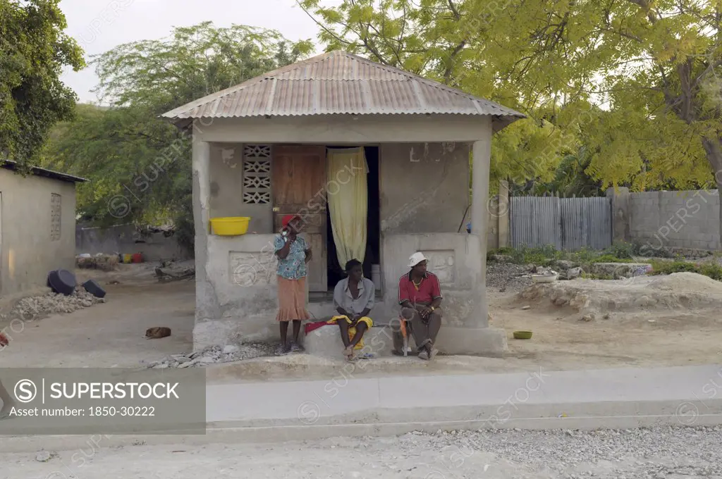 Haiti, Isla De Laganave, Local People Sat Outside Hime With Tin Roof.
