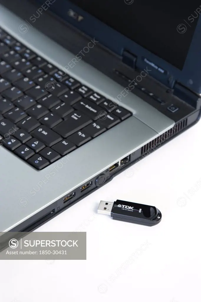 Industry, Computers, Components, 8 Gigabyte Portable Usb Flash Drive Storage Device Beside Laptop Computer Usb Port.