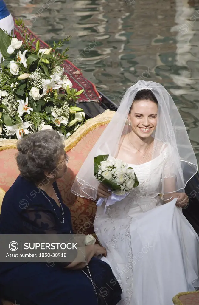 Italy Veneto Venice, bride in wedding dress and veil on gondola