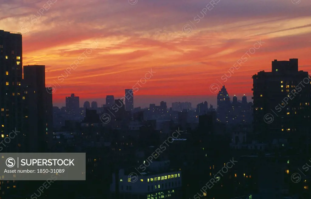 USA, New York State, New York, Upper East Side city skyline at dusk with red and purple sunset sky.