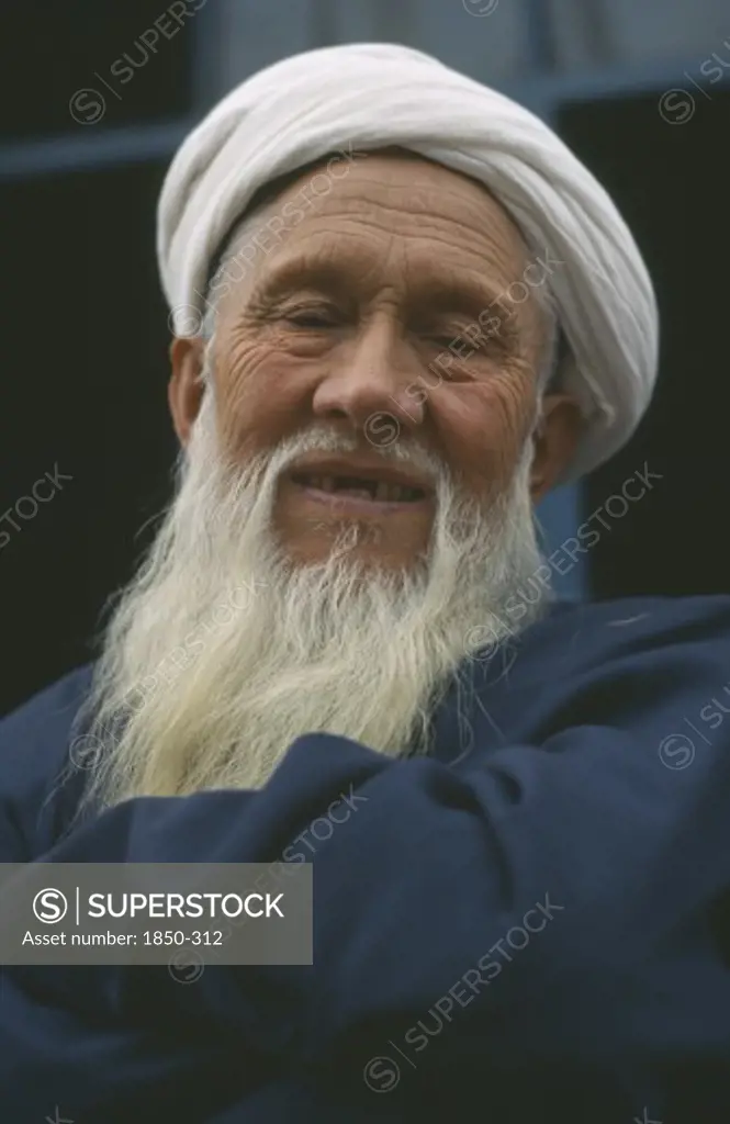 China, Xinjiang, Kashgar, White Bearded Smiling Kazakhi Man In Blue Wearing White Turban