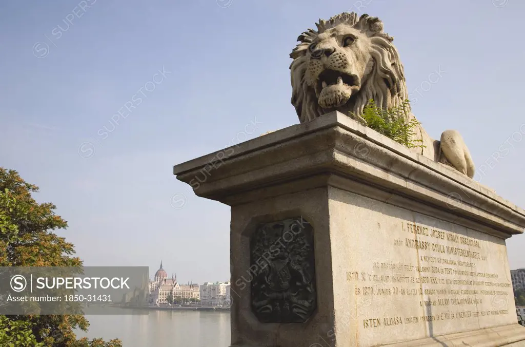 Hungary Pest County Budapest, Lion sculpture on the Chain Bridge with Hungarian Parliament Building