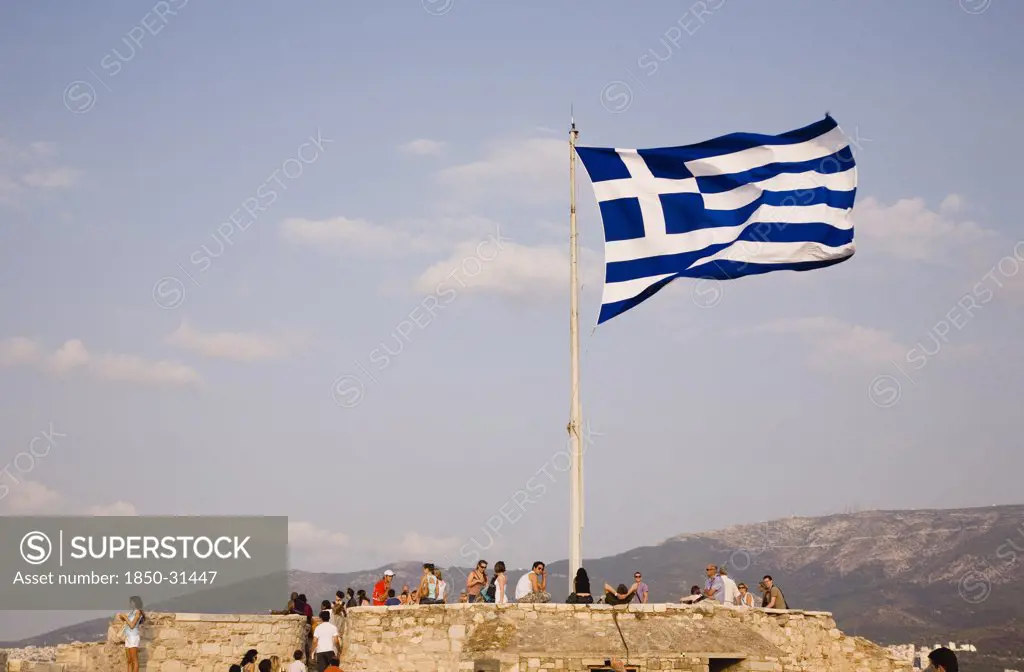 Greece Attica Athens, Acropolis  Greek flag flying with tourists