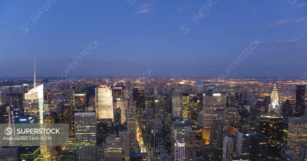 USA, New York, New York City, Manhattan  View from Empire State building over midtown skyscrapers with Art Deco Chrysler Building illuminated at sunset.