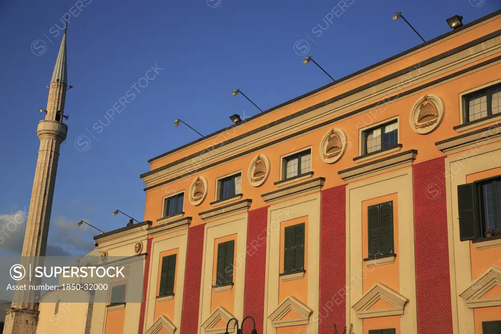 Albania, Tirane, Tirana, Pink and yellow government building facades beside minaret of Ethem Bey Mosque in Skanderbeg Sqaure.