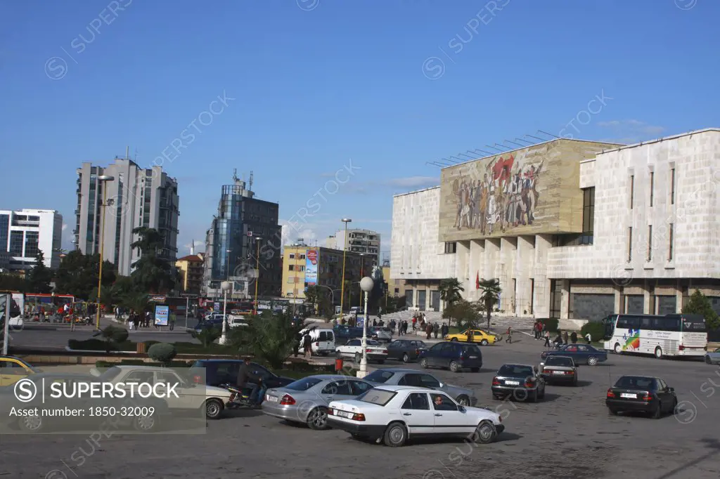 Albania, Tirane, Tirana, Traffic in Skanderbeg Square passing exterior facade of the National History Museum to the right.