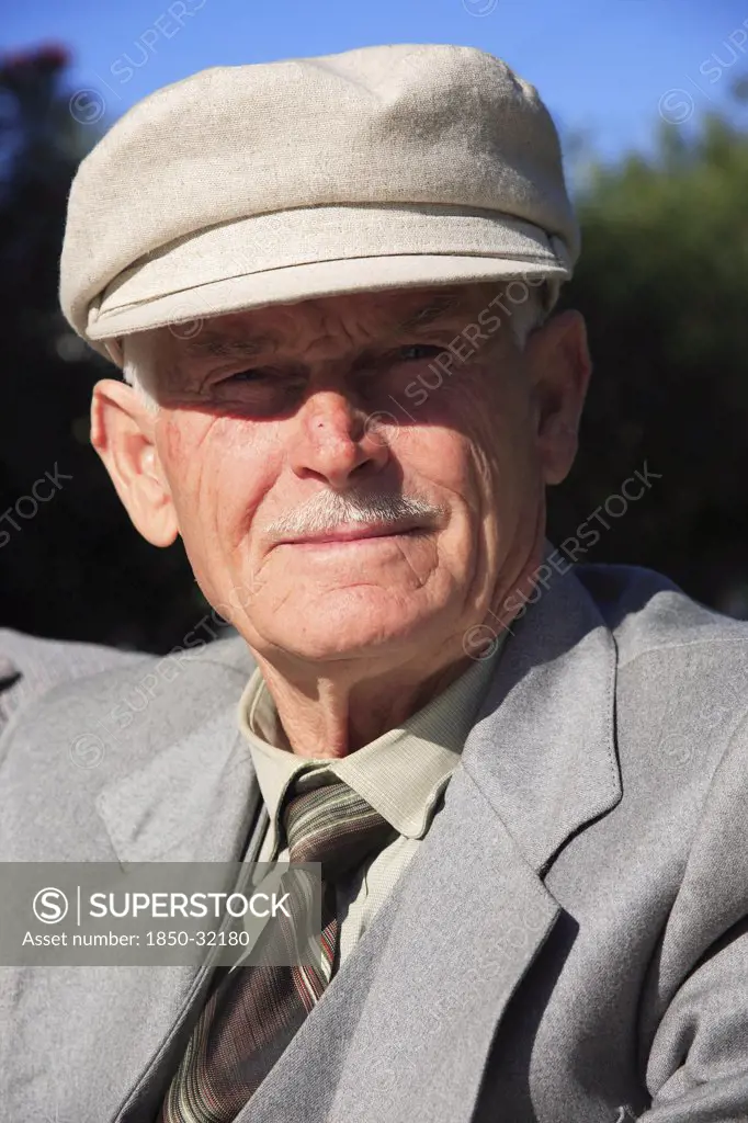 Albania, Tirane, Tirana, Head and shoulders  full face portrait of an elderly man wearing a hat.