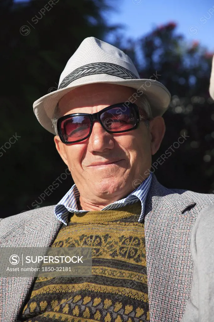 Albania, Tirane, Tirana, Head and shoulders full face portrait of a middle-aged man wearing a hat and sun-glasses.