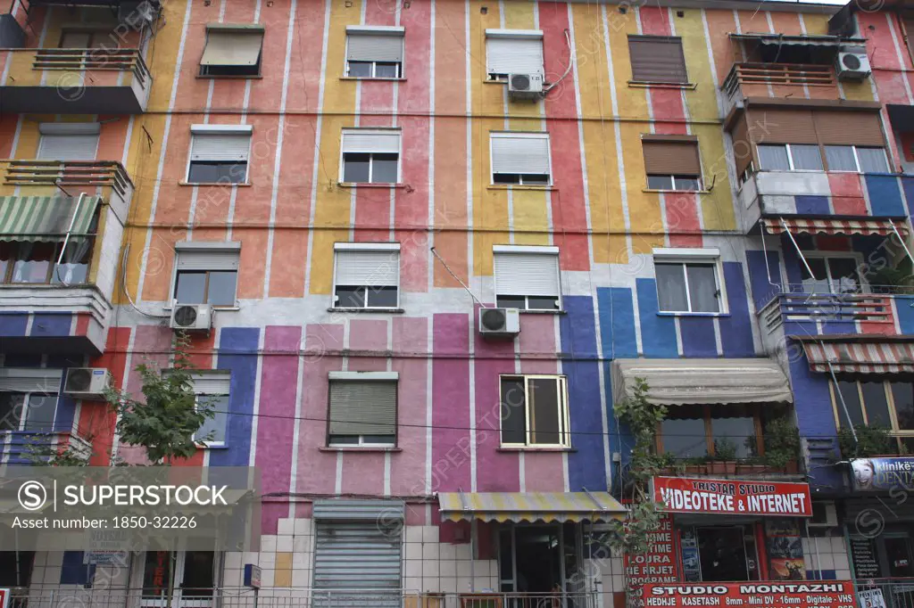 Albania, Tirane, Tirana, Exterior facade of striped  multi-coloured apartment block with windows  window blinds and air conditioning units.