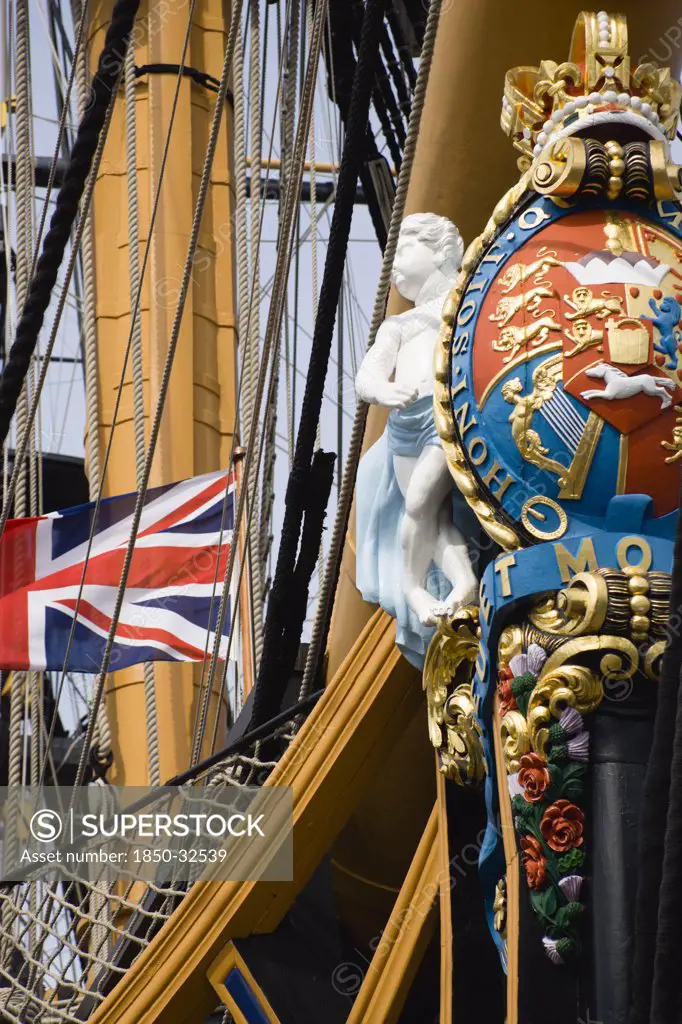 ENGLAND, Hampshire, Portsmouth, Bow and rigging of Admiral Lord Nelson's flagship HMS Victory showing the ship's figurehead with Royal Crest and Union Flag in the Historic Naval Dockyard.