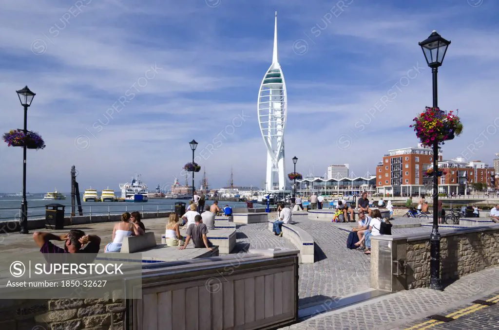 ENGLAND, Hampshire, Portsmouth, Harbour with the 170 metre tall Spinnaker Tower seen from Spice Island with people sitting in Bath Square.