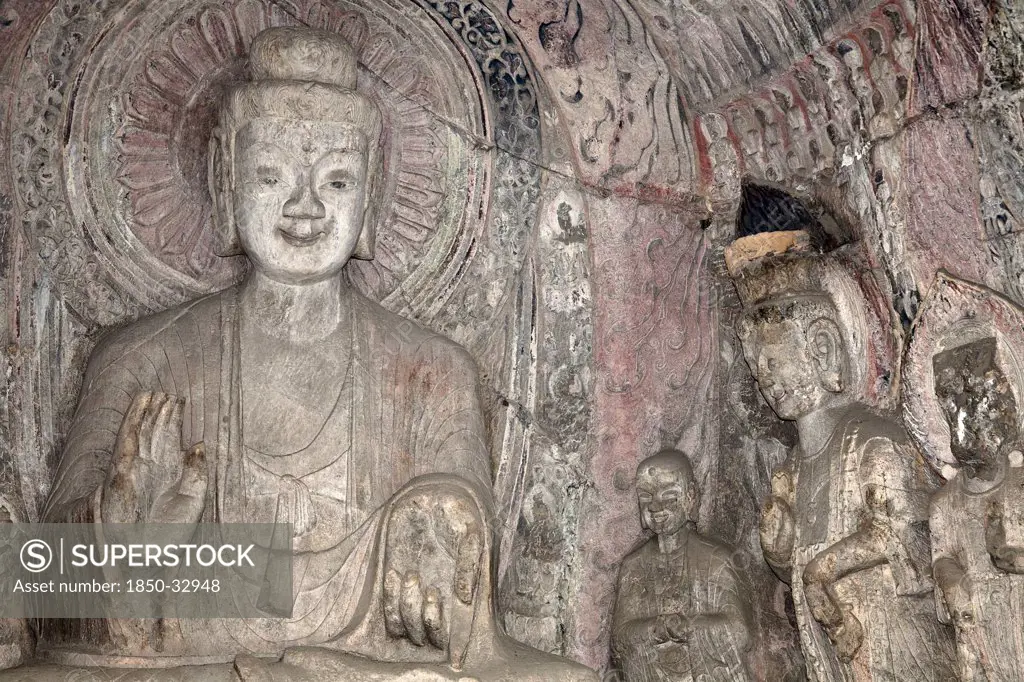 China, Henan Province, Luoyang, A carved stone Buddha, carved from the rock, Longmen Grottoes and Caves.