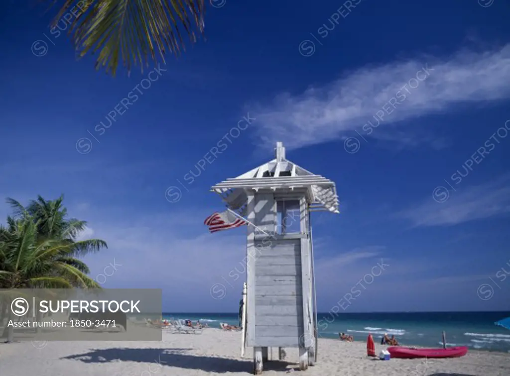 Usa, Florida , Fort Lauderdale, Lifeguard Hut On Occupied Sandy Beach With American Flag Flying