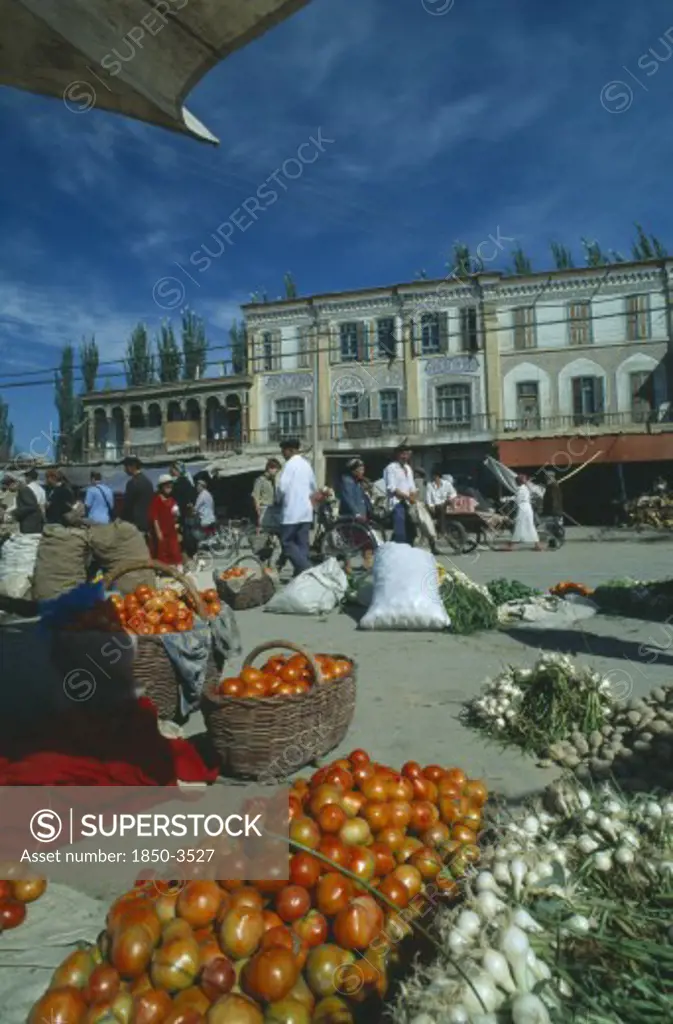 China, Xinjiang, Kashgar, Vegetables For Sale On The Street In Front Of Three Storey Buildings At The Sunday Market