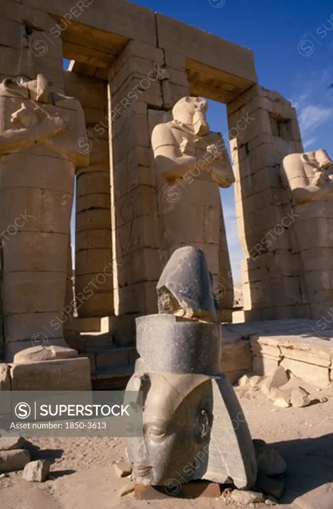 Egypt,  , Luxor, Osirid Columns In Front Of Temple With Head Of Statue On Ground