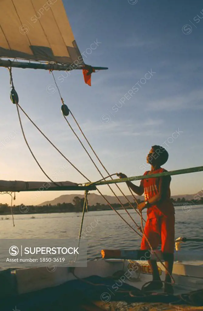 Egypt,  , Transport, Felucca On The River Nile In The Evening With Young Boy Adjusting Rigging