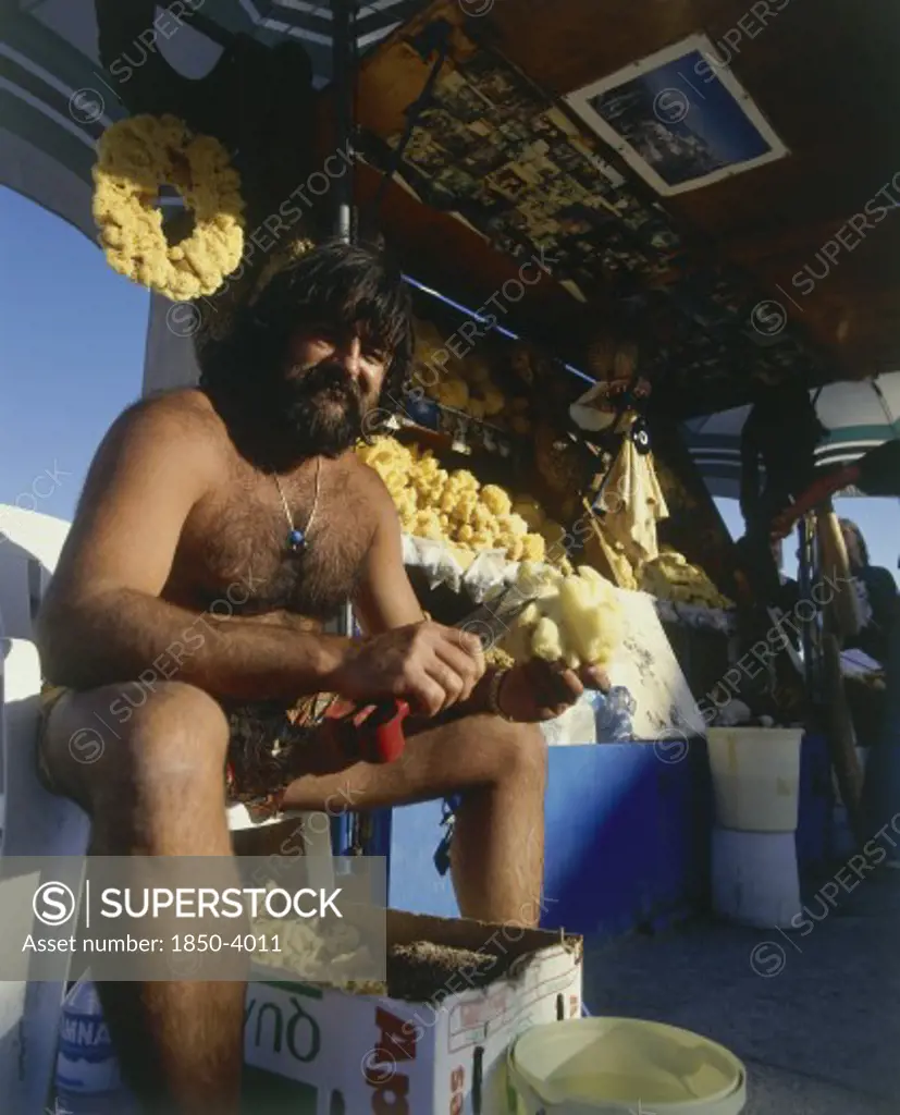 Greece, Dodecanese Islands, Kos, Kardamina Fisherman Cleaning Sponges At His Natural Sea Products Stall