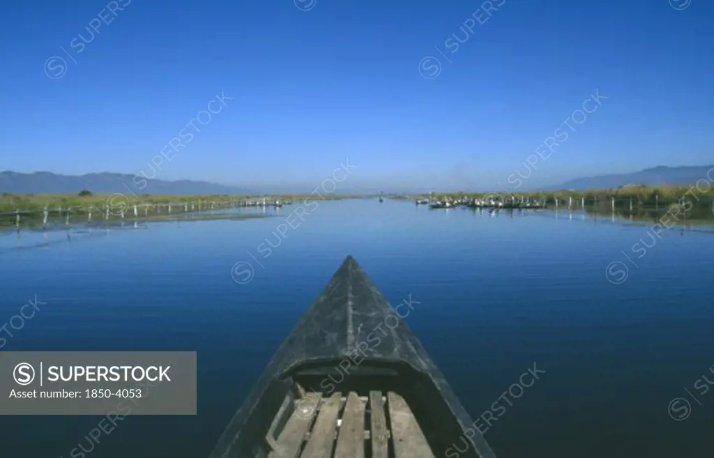 Myanmar, Inle Lake, View Along Canal Over The Prow Of A Wooden Boat