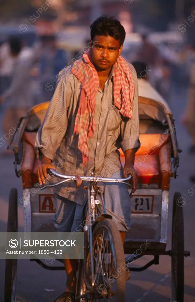 India, Uttar Pradesh, Delhi, Rickshaw Driver Cycling On The Road In The Early Morning