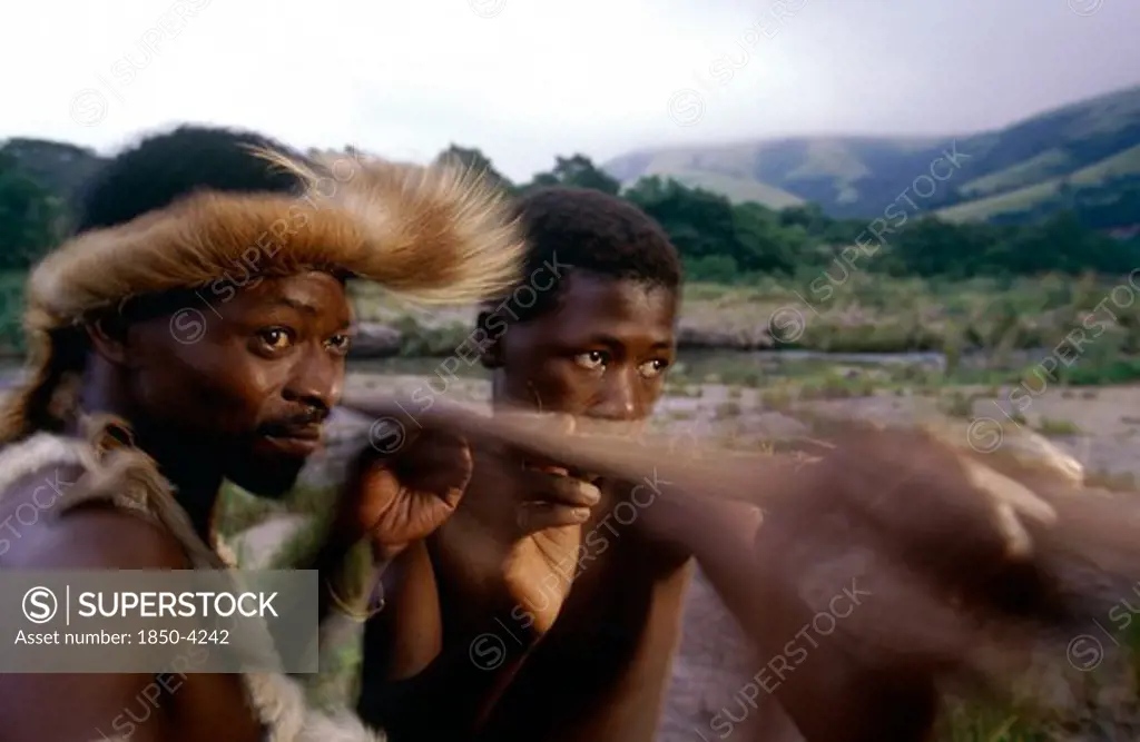 South Africa, Kwazulu Natal, Melmoth, Zulu Man Teaching Young Boy How To Throw A Spear.