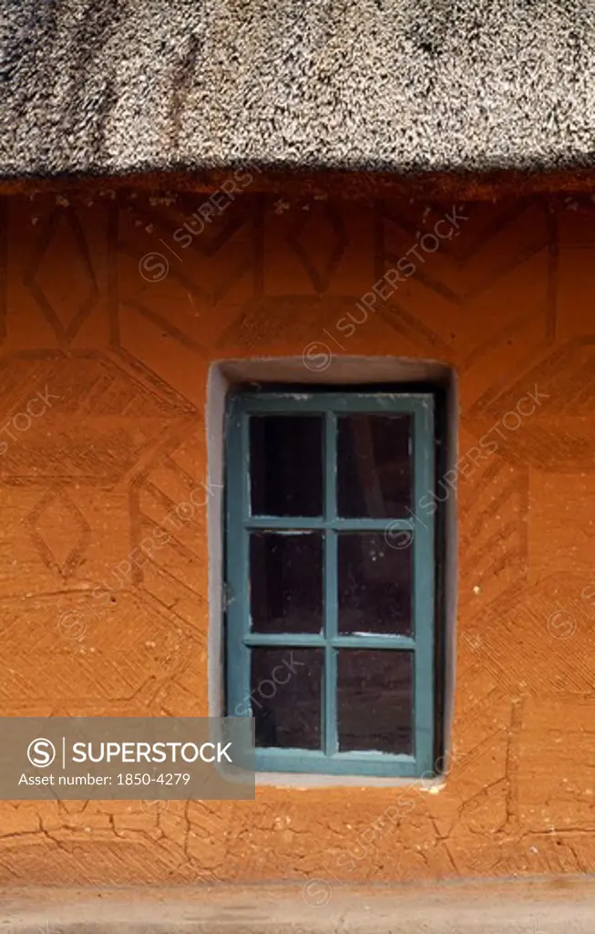 South Africa, Qwa Qwa, Basotho Cultural Village, Detail Of Typical House With Green Framed Window In Recess And Orange Walls.