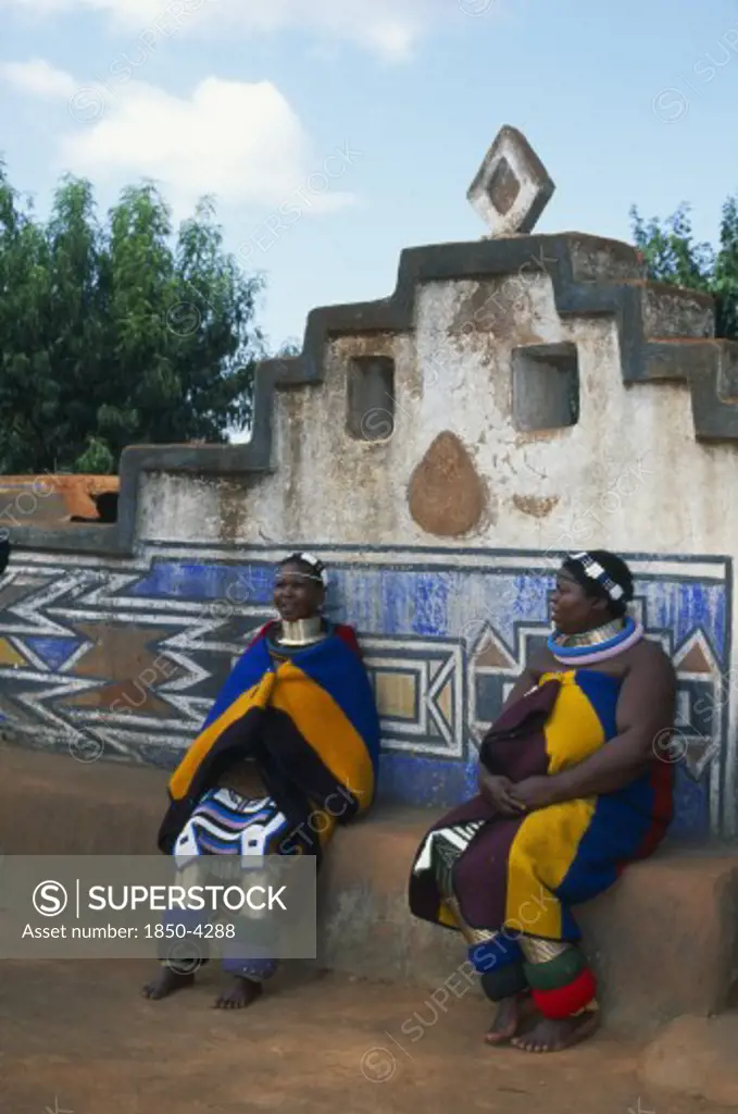 South Africa, Mpumalanga, Middelburg, Botshabelo Ndebele Village (Formerly Missionary Station) Two Local Women In Traditional Dress Sitting Down.