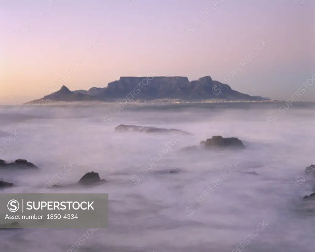 South Africa, Cape Province, Cape Town, View Of Table Mountain At Dawn Taken From Bloubergstrand Shore Line With Heavy Mist.