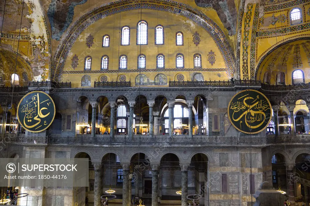 Turkey,  Istanbul, Sultanahmet Haghia Sophia Sightseeing tourists in the North Gallery with Koranic Islamic calligraphic roundels of Arab text.