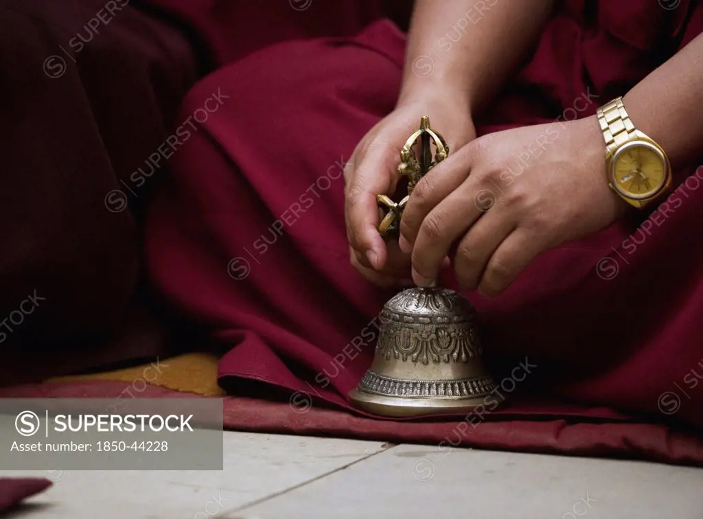 India,  Sikkim,  Buddhist Monk playing musical bell in a Losar ceremony