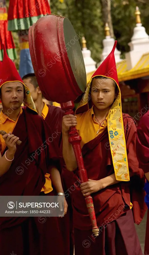 India,  Sikkim, Buddhist Monk playing a drum in a Losar ceremonial procession.