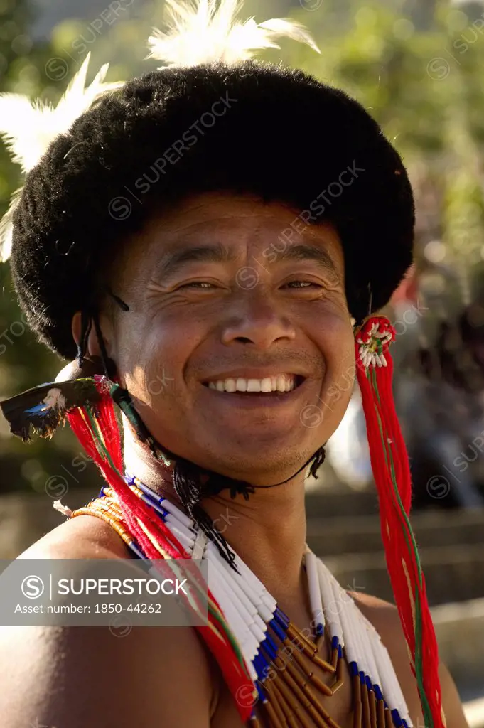 India, Nagaland, People, Smiling Naga Warrior tribal in traditional costume and head dress.