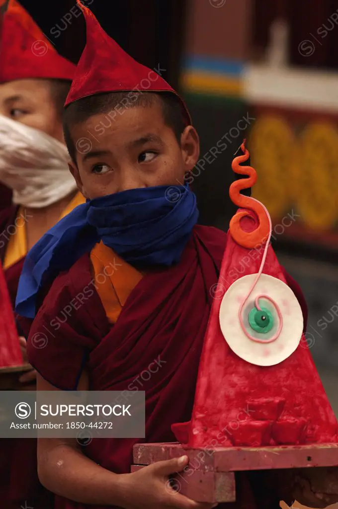 India,  People,  Buddhist monk carrying a wax art offering for the Losar ceremony