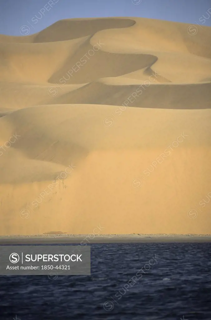 Namibia, Namib , Naukluft Desert, Sand dunes of the Langevaan a 1000 foot high wall of sand where the desert meets the Atlantic ocean. Access is restricted due to Diamond mining activity by DeBeers.