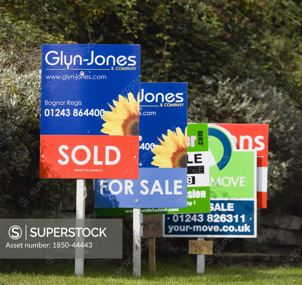 Business, Finance, Real Estate , Estate agents signs on posts advertising property for sale and sold.