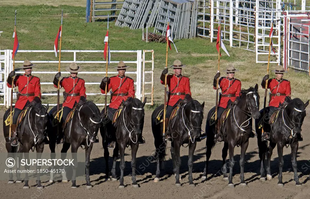 Royal Canadian Mounted Police Musical Ride RCMP cavalry in full dress red serge uniform on horseback holding lances with red and white pennons.Canada Alberta Lethbridge
