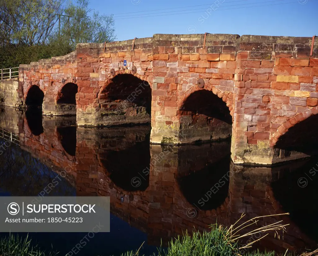 Bridge on the B4080 crossing the River Avon and constructed from sandstone blocks reflected in the river below.England Hereford And Worcester Eckington