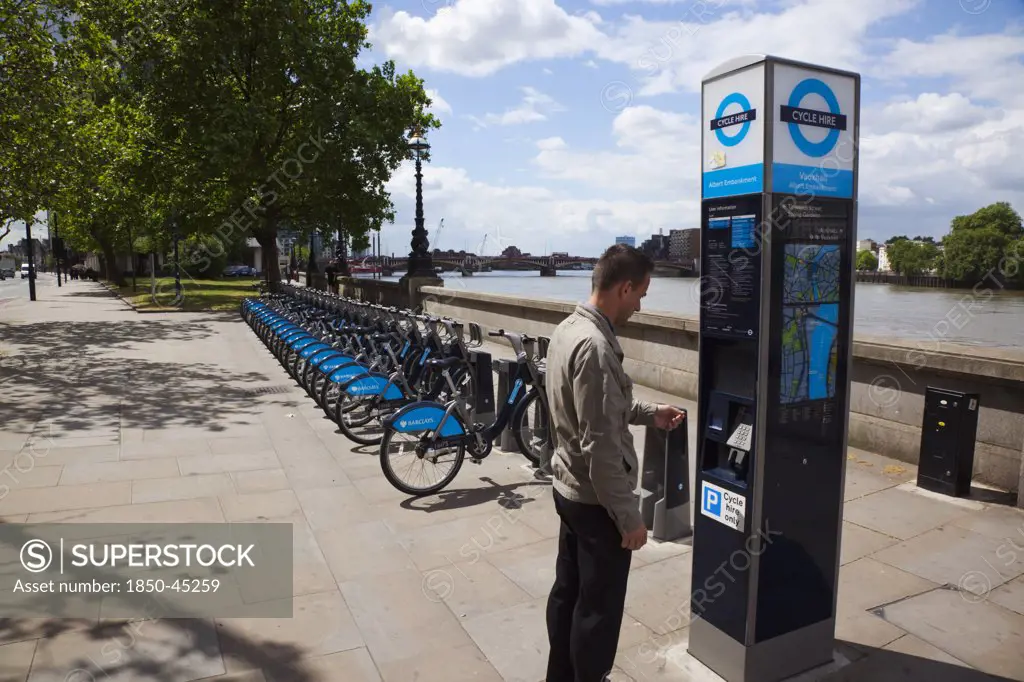 Vauxhall Albert Embankment of the river Thames man buying time on bicycle hire self service machine.England London