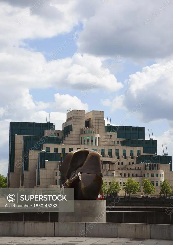 MI6 Headquarters on the Albert Embankment in Vauxhall seen from Millbank with a Henry Moore bronze Locking Piece sculpture in the foreground. , England London