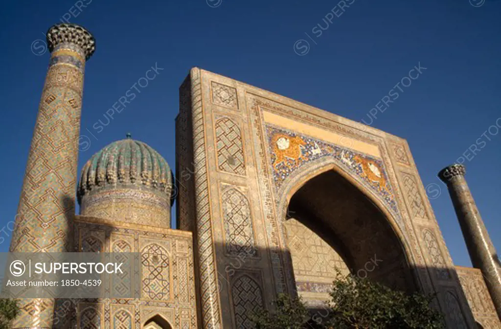 Uzbekistan , Samarkand, Registan , 'Shir Dor Madrassah, Detail Of The Decorated Arch, Dome And Tower Of The Muslim College Partially Cast In Shadow'
