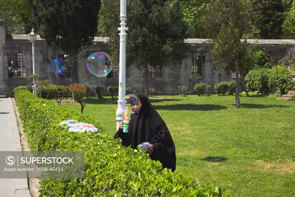 Istanbul Sultanahmet woman selling bubble gun machine in park outside the Blue Mosque.Turkey Istanbul