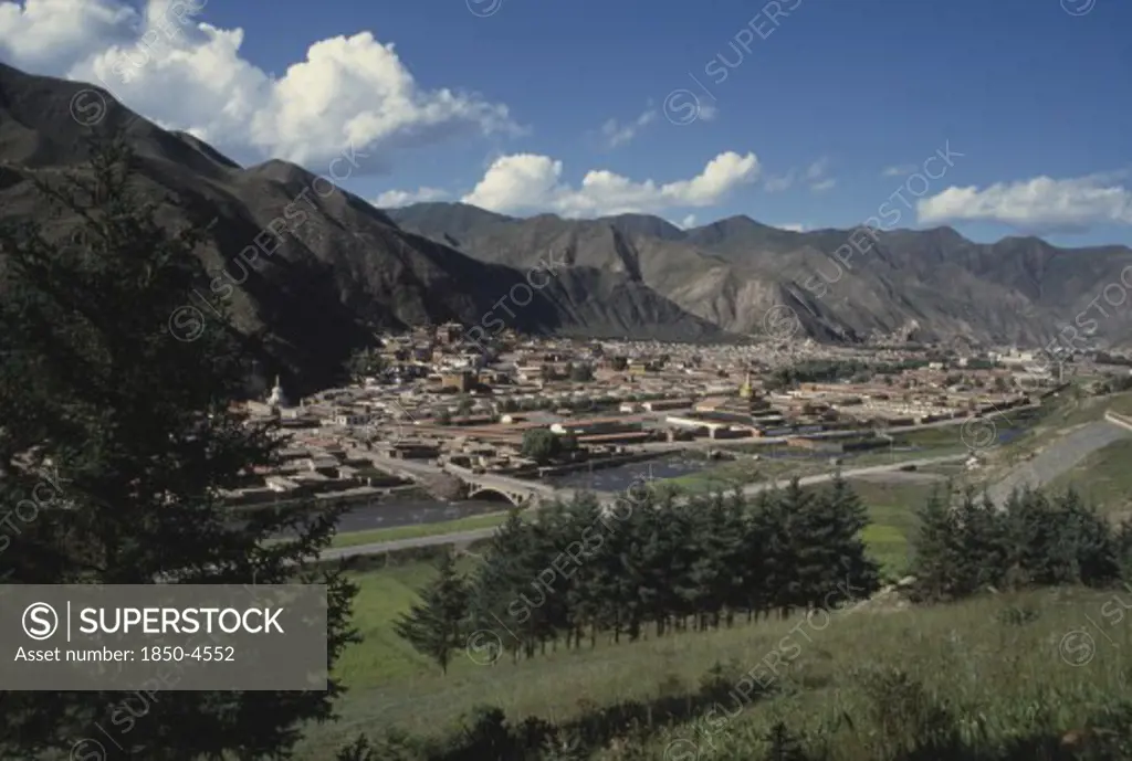 China, Gansu, Xiahe, General View Over Labrang Monastery From A Distance With Surrounding Hills
