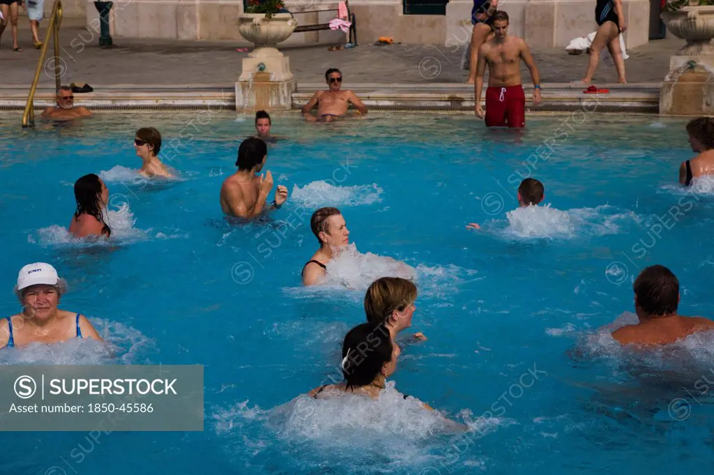 Hungary, Budapest, Pest, Mixed group outdoor bathing in summer at Szechenyi thermal baths, largest in Europe.