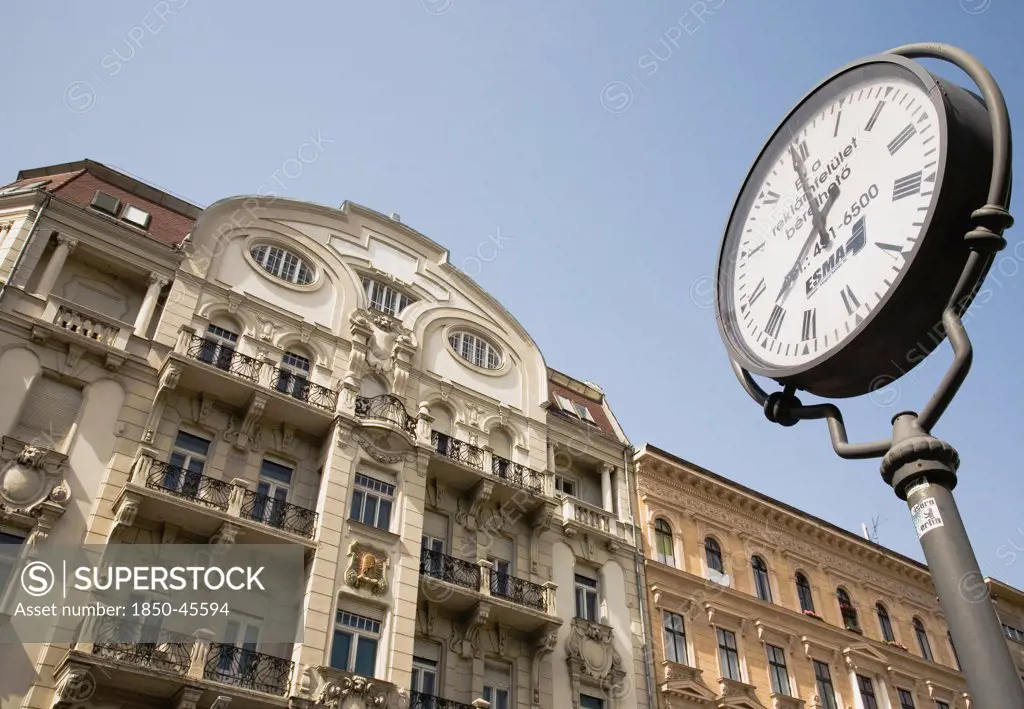 Hungary, Budapest, Clock with Art Nouveau facade behind  in central Pest.