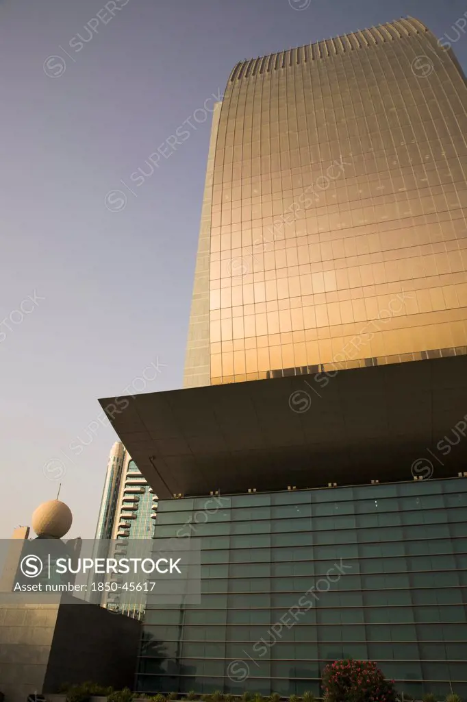 UAE , Dubai,  Curved glass facade of National Bank of Dubai building with Etisalat tower behind